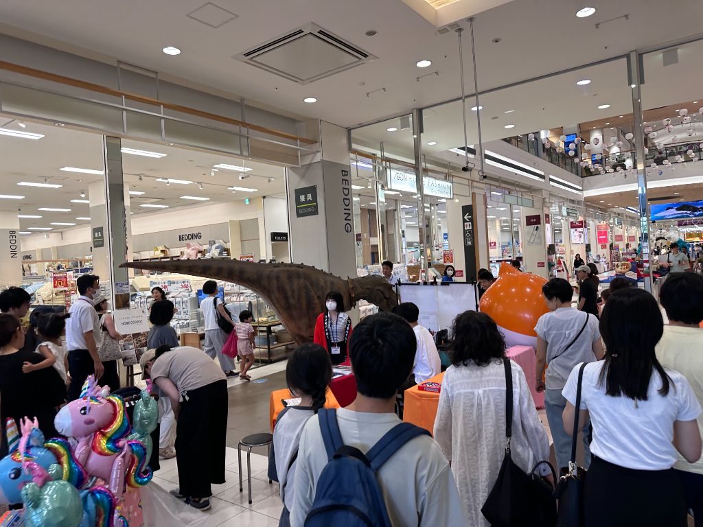 千葉県の商業施設で恐竜ウォークに集まる大勢の来場者。館内を恐竜が歩く様子を見守る家族連れ